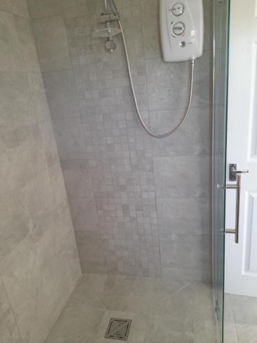 a bathroom with a shower with a glass door at Sunray in Langton Matravers