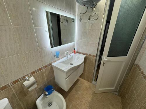 a bathroom with a toilet and a sink and a mirror at Taulant in Sarandë