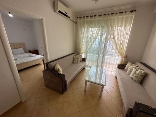 a living room with a couch and a bed and a window at Taulant in Sarandë