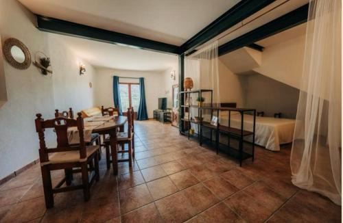 a living room with a table and chairs and a bed at Cases Tonet Apartamento-loft in Forcall
