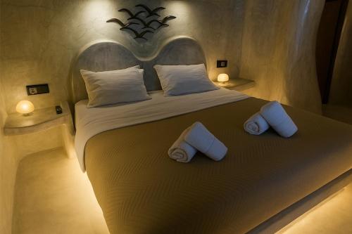 a bedroom with a large bed with two pillows at Selora Cave in Pirgos