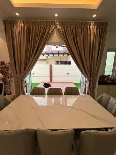 a dining room with a large table and chairs at Heartstay Tanjong Karang 妍菁名宿 in Kampong Tanjong Karang