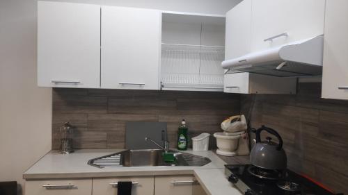 a kitchen with white cabinets and a sink at Forrest House w Białej in Sulejów