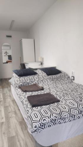 a bed with black and white sheets and pillows at Forrest House w Białej in Sulejów