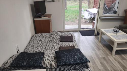 a bedroom with a bed with a blanket and a table at Forrest House w Białej in Sulejów