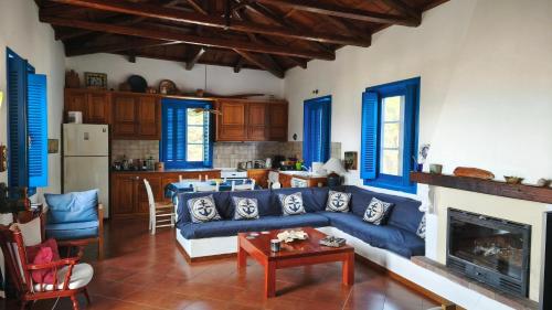 un soggiorno con un divano blu e un tavolo di Stamos house a Hydra