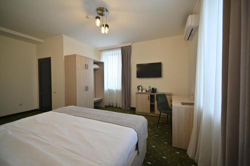 a hotel room with a bed and a desk at Colette Hotel in Yerevan