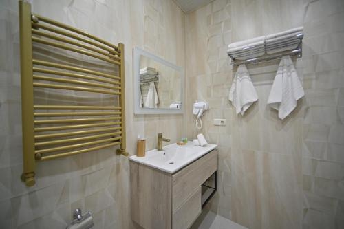 a white bathroom with a sink and a mirror at Colette Hotel in Yerevan