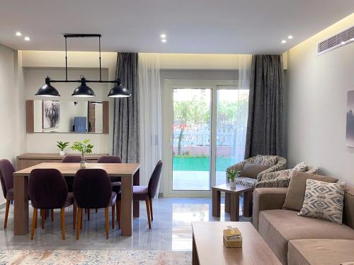 a living room with a table and a dining room at شقة فاخرة 3 غرف نوم و حديقة خاصة في الشيخ زايد - Zayed Suites A in Sheikh Zayed