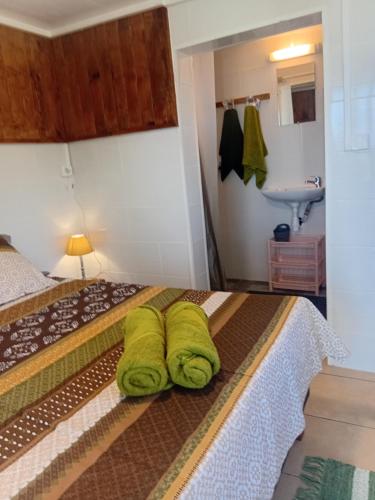 Maison HenouにあるLe BOA VISTAのベッドルーム1室(ベッド1台、緑のタオル2枚付)