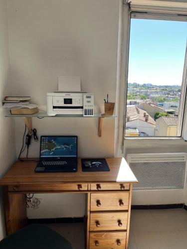 un bureau avec un ordinateur portable et un micro-ondes sur une fenêtre dans l'établissement Saint louis, à Marseille