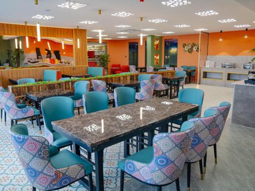 a dining room with tables and blue chairs at Bojon Hotel Ulaanbaatar - Soyolj Mall in Ulaanbaatar