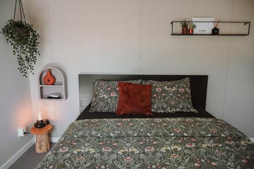 a bedroom with a bed with a flowered bedspread at Badhuisje aan Zee op Huisduinen in Huisduinen