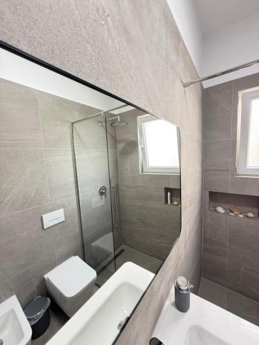 a bathroom with a sink and a toilet and a mirror at GuestHouse Brahja, Tirana in Sauk