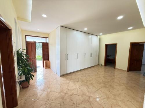 a large room with white cabinets and a tile floor at GuestHouse Brahja, Tirana in Sauk