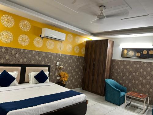 a hotel room with a bed and a blue chair at Tanvi Premium Residency-Close to Artemis, Medanta & Fortis in Gurgaon