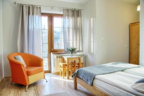 a bedroom with a bed and a chair and a table at DW Pod Jaworami - relaks - jacuzzi, sauna na wyłączność in Białka Tatrzanska