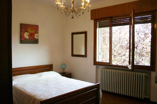 1 dormitorio con cama y lámpara de araña en B&B Fortuines, en Monselice