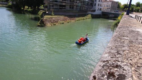 a person in a small boat in a river at Le gîte embarqué - Géré par Presta-Zen'Services - Barque électrique en supplément in Verdun
