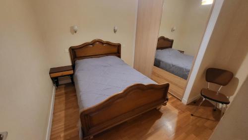 une petite chambre avec un lit et un miroir dans l'établissement type 2, à Vic-sur-Cère