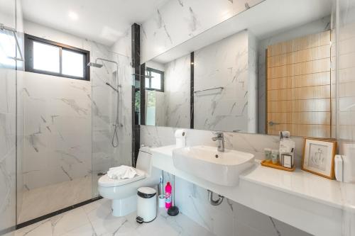 une salle de bain avec un lavabo, des toilettes et une douche dans l'établissement V190 Tropical Oasis 3BR Villa with Pool & Bathtub, à Ban Saiyuan (1)