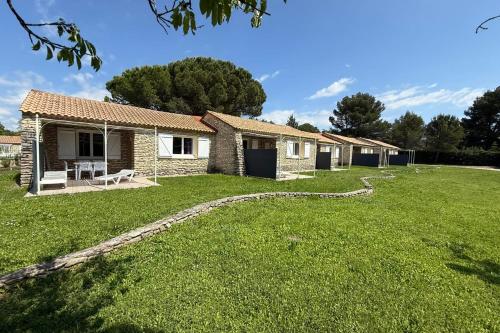 Une rangée de maisons dans une cour herbeuse dans l'établissement Cozy T2 cottage with private terrace, à La Roque-sur-Pernes