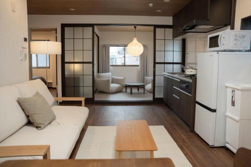 a living room with a white couch and a kitchen at 大田Nishikōjiya hotel-OT0368 in Tokyo
