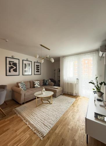 a living room with a couch and a table at Cozy Flat near Airport & Sarajevo Center, Free Parking in Sarajevo