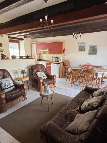 un salon avec des meubles en cuir et une table dans l'établissement Repos de l'Île aux Pies, à Saint-Vincent-sur-Oust