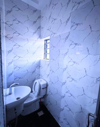 a white bathroom with a sink and a toilet at Stobi Apartment in Karsana