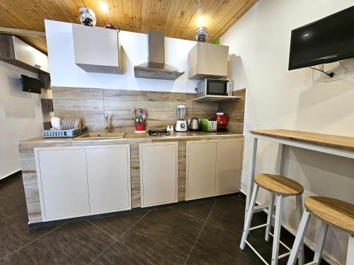 a kitchen with white cabinets and a counter at Duomo Suite - A Step from the Cathedral in Monreale