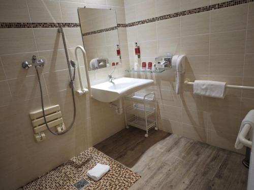 a bathroom with a sink and a shower at Hotel Capitole in Beausoleil