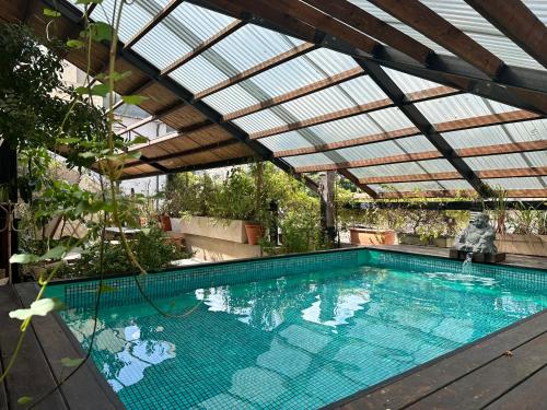 an indoor swimming pool with a glass roof and a swimming pool at otto7senses in Haifa