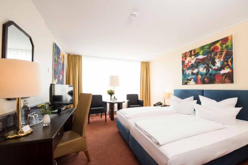 Postel nebo postele na pokoji v ubytování Carathotel Basel/Weil am Rhein