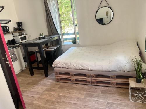 a bedroom with a bed and a desk and a mirror at Studio coeur de ville in Figeac