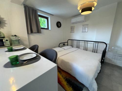 a bedroom with a bed and a desk with chairs at Studio Karin in Trviž