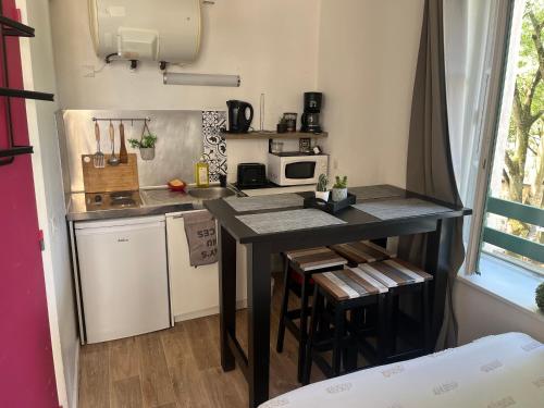 - une petite cuisine avec une table et un comptoir dans l'établissement Studio coeur de ville, à Figeac