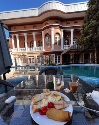 タシュケントにあるArt House Hotelの建物の前のテーブルに置かれた食べ物の皿
