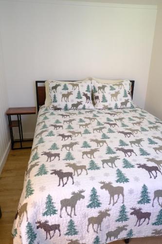 a bed with a blanket with horses on it at Green Hill at Rainier Lodge (0.4 miles from the entrance) in Ashford