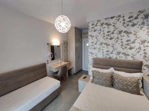 a hotel room with two beds and a bathroom at Studios Apollon in Chrysi Ammoudia