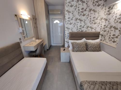 a bedroom with a bed and a sink and a mirror at Studios Apollon in Chrysi Ammoudia
