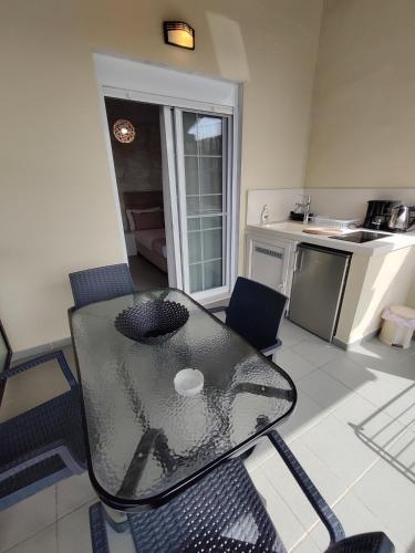 a kitchen with a glass table and chairs in a room at Studios Apollon in Chrysi Ammoudia