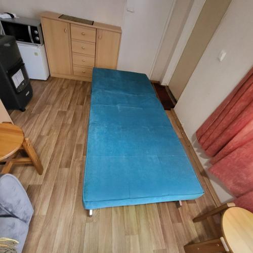 a blue couch in a room with a table at Camping House Aivari in Inčukalns