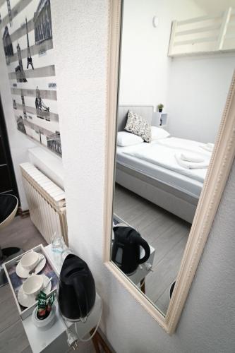 a mirror in a small room with a bed and a bed sqor at Old Town Whisper Apartments in Sarajevo