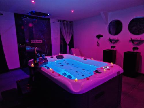 a room with a hot tub in a purple room at Nuit Blanche Normandie in Eu