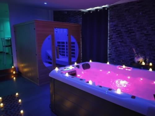 a large bathroom with a pink tub with lights at Nuit Blanche Normandie in Eu