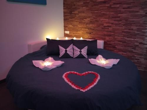 a bed with a heart and two candles on it at Nuit Blanche Normandie in Eu