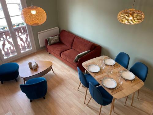 un salon avec un canapé, une table et des chaises dans l'établissement Le Petit Carrousel, à Gérardmer