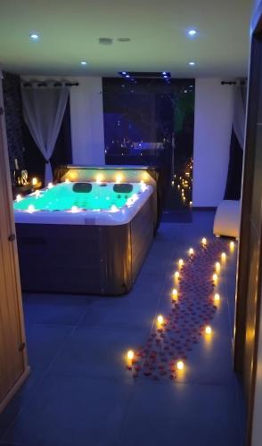 a bathroom with a tub with candles and lights at Nuit Blanche Normandie in Eu
