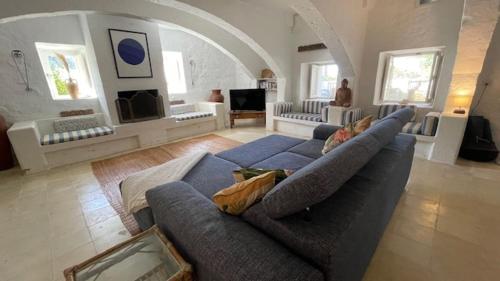 a living room with a blue couch and an archway at Casa Palma Gozo in Għarb